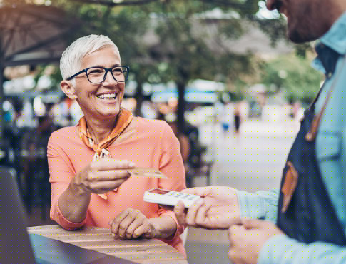 Mature woman paying at cafe.