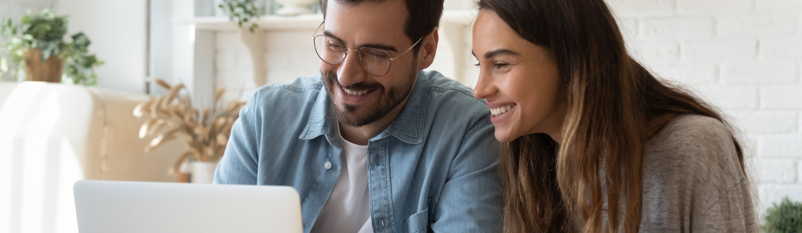 Couple look at computer together.