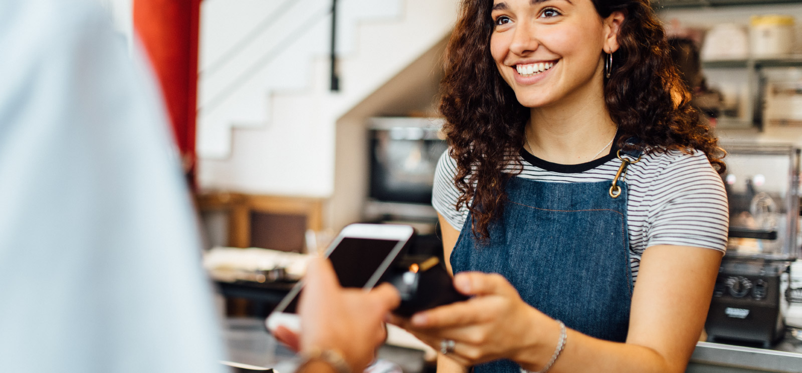 Woman taking a payment at cafe.