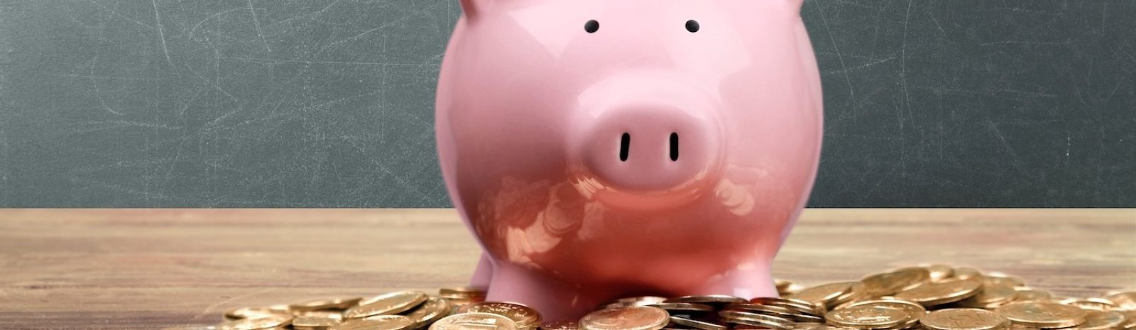 pink piggy bank surrounded by pennies