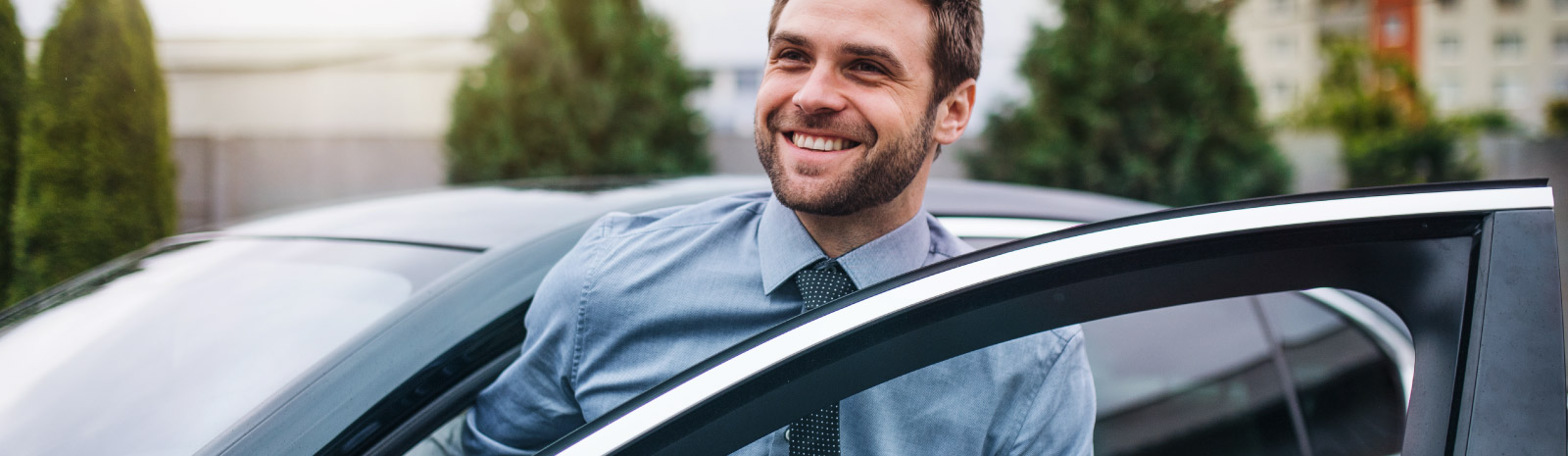 Happy man gets out of his car.