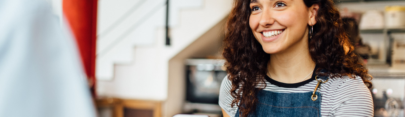 Friendly woman smiles at customer.