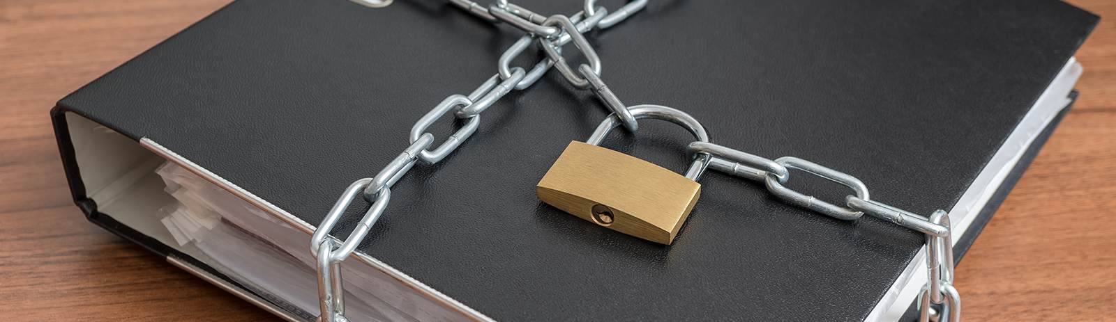 black binder surrounded by a pad lock